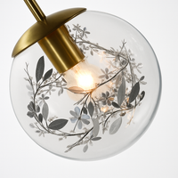 Design wandlamp in glas gevuld met gouden bladeren, hangend