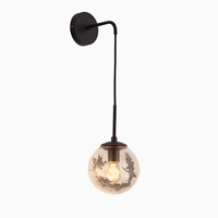 Design wandlamp in glas gevuld met gouden bladeren, hangend